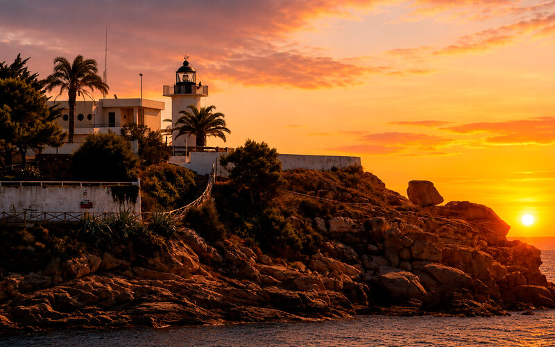 Faro de Palamós durante la puesta de sol en la Costa Brava.